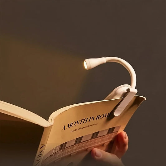 Clip-on reading light over an open book with text highlighting features.