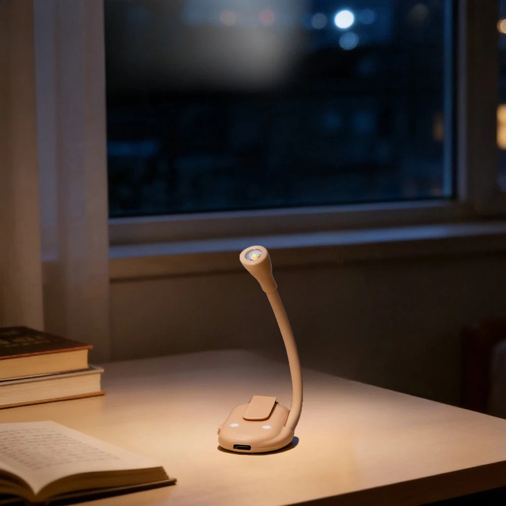 Desk lamp on a table with books and a window in the background