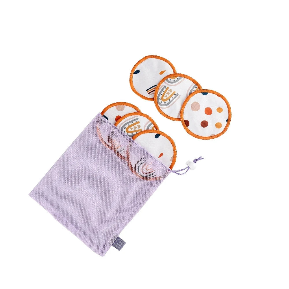 A lavender mesh drawstring pouch containing three reusable cloth pads with orange trim and multicolor printed designs, shown on a white background with a small label at the top reading D.