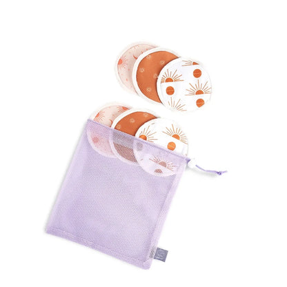 A lavender mesh drawstring pouch containing reusable menstrual cups with orange and white sunburst patterns, shown on a white background with a purple 'G' label at the top.