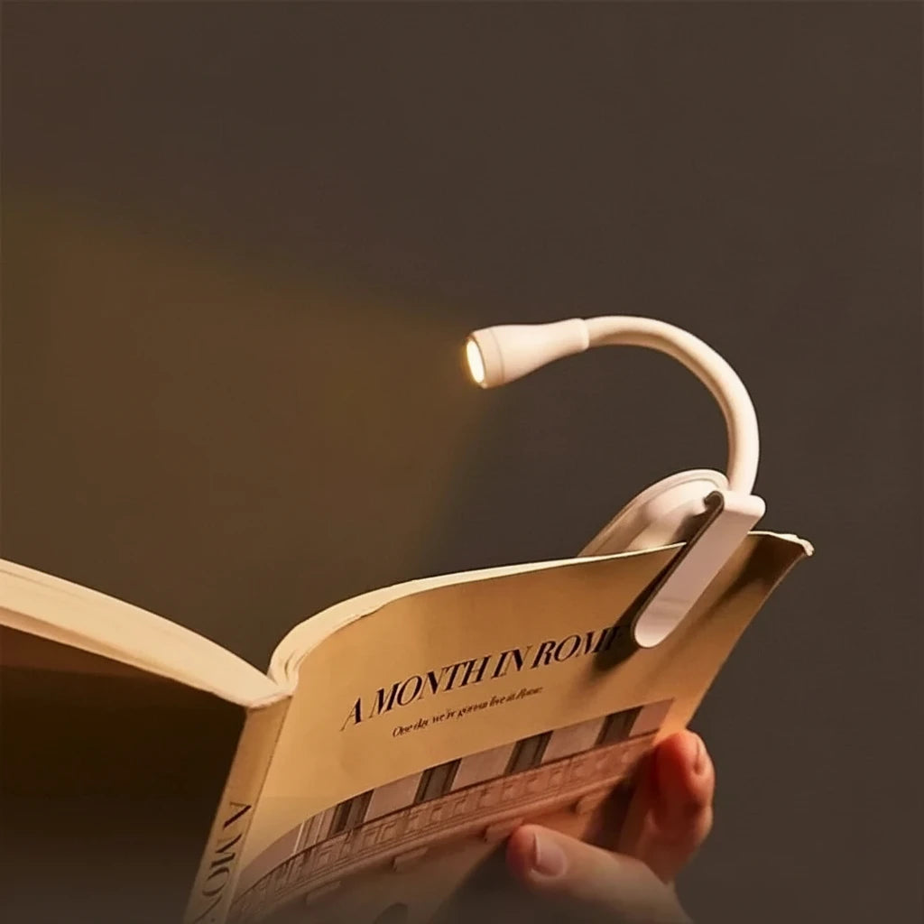 Clip-on reading light over an open book with text highlighting features.