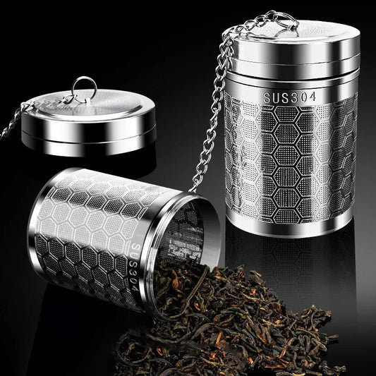 Stainless steel tea infuser with honeycomb design on a black background
