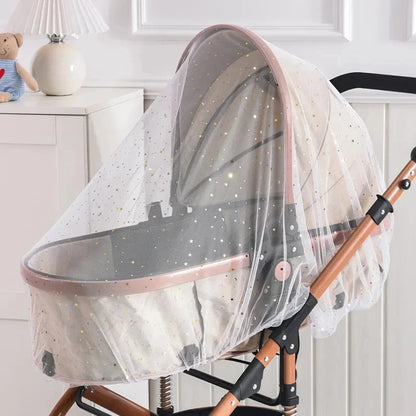 Baby bassinet with mosquito net attached to a stroller in a nursery setting.