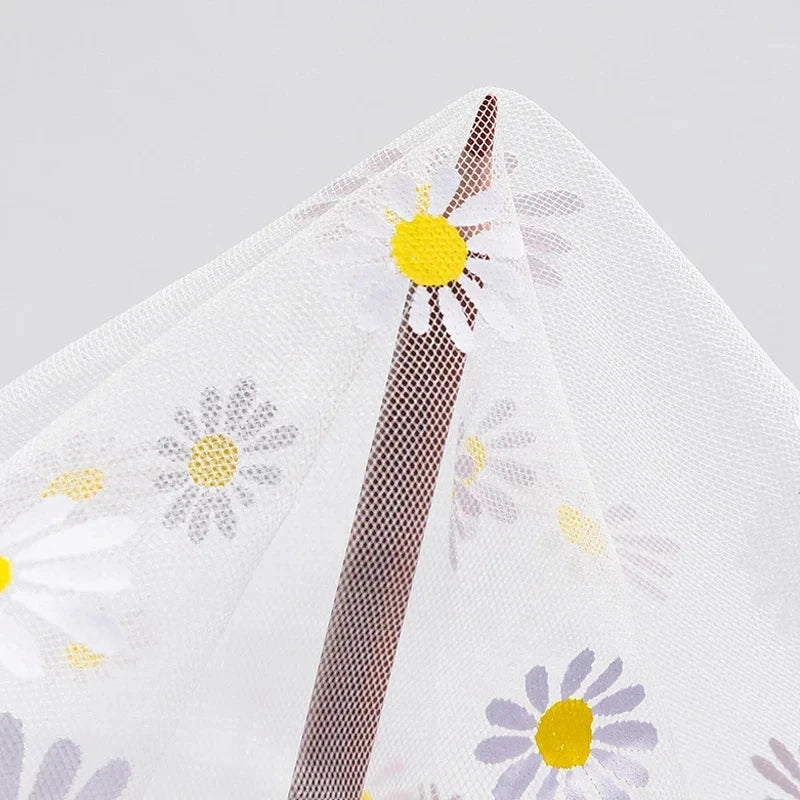 White fabric with floral patterns and a textured brown strip on a gray background