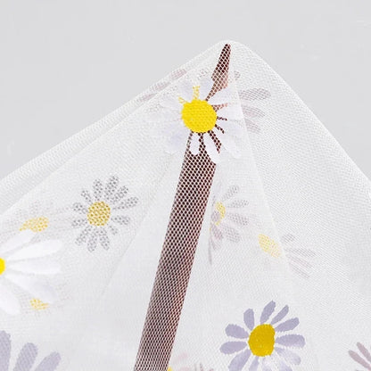 White fabric with floral patterns and a textured brown strip on a gray background